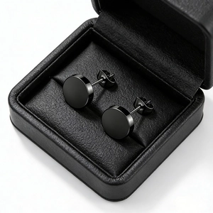Close-up of polished black stainless steel stud earrings in a luxury jewelry box