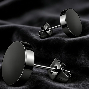 Close-up of black stainless steel stud earrings with butterfly backs on black velvet