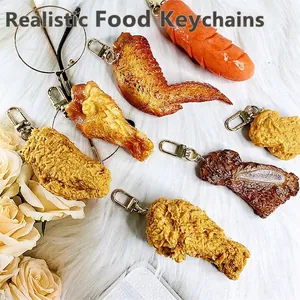 Realistic fried chicken keychain set with drumstick and wings on white fur background