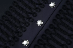 Detail of navy military jacket featuring black braided frogging and silver metal buttons