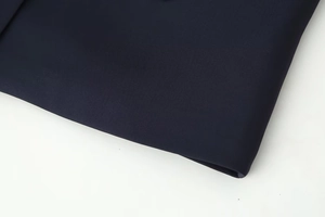 Detailed close-up of dark blue textured fabric showing fine material weave and quality finish