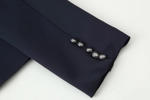 Detail of dark blue sleeve cuff featuring five decorative grey metallic buttons