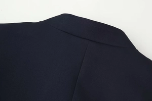 Detailed close-up of navy blue high-density woven fabric and stitching on the jacket collar