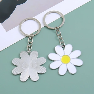 Daisy alloy keychain with white petals and yellow center shown from front and back view