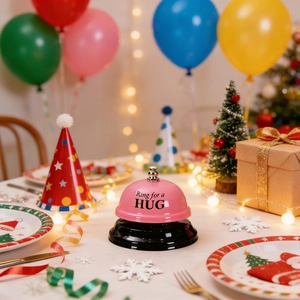 Pink metal service bell featuring Ring for a HUG text on festive party background