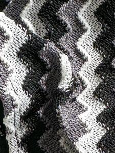 Macro shot of wavy striped knit swimwear fabric in black, white and grey texture