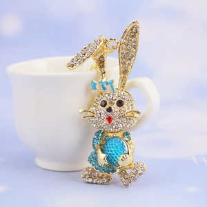 Macro detail of a golden bunny keychain with sparkling blue rhinestones and crystal gemstone