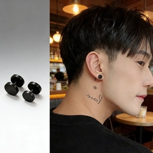 Unisex black titanium steel barbell stud earrings with matte disc design on male model