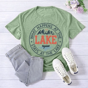 Detail of pea green T-shirt with lake print, 2XL tag, and rustic lifestyle props