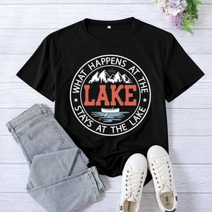 Flat lay of black lake graphic tee with mountains and canoe on wood background