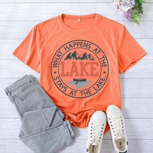 Close-up of orange t-shirt with Lake theme graphic print on white wooden background