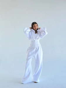 Détail du survêtement blanc avec capuche et taille cintrée au design de corset