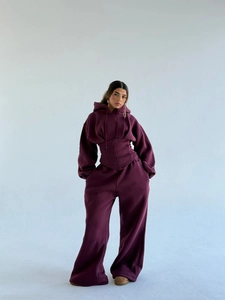 Détail d'un ensemble bordeaux avec sweat à capuche style corset et pantalon large de sport