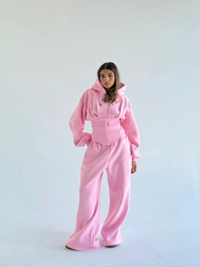Détail du haut à capuche cintré rose et du pantalon large en ensemble deux pièces
