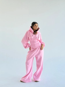 Détail d'un ensemble de sport rose deux pièces avec sweat à capuche corset et pantalon large