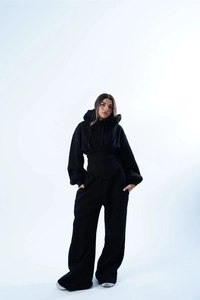 Détail d'un ensemble de survêtement noir avec sweat à capuche court et pantalon large