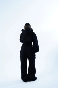 Vue arrière du sweat à capuche noir ajusté et du pantalon large avec lien à la taille