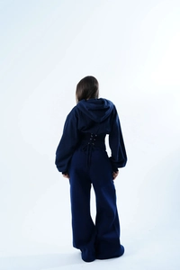 Détail du sweat à capuche bleu marine avec laçage au dos et pantalon large assorti