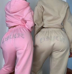Detailansicht der gotischen EXPLICIT-Stickerei auf beige und rosa Freizeit-Shorts-Sets