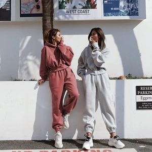 Detail view of oversized hooded tracksuit for women in rust red and light grey fabrics