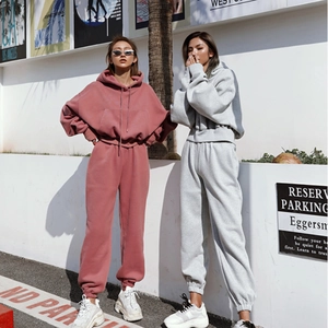 Detail of loose fit hooded sweatshirt and joggers set with pockets in casual style