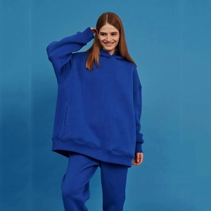 Detail eines königsblauen Oversize-Kapuzenpullover-Sets mit Rippbündchen und weichem Stoff
