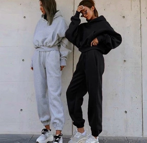 Detail of gray and black hooded tracksuits featuring cropped hoodies and joggers
