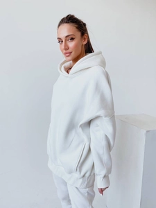 Detailansicht des weißen Oversize-Hoodies mit überschnittenen Schultern und Bündchen