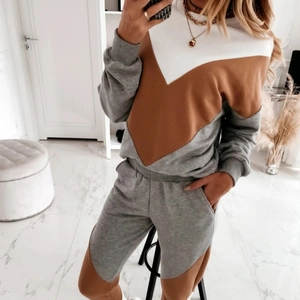 Detail van colorblock sweatshirtset met V-vormig patchwork in wit, bruin en grijs
