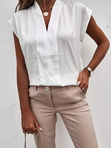 Detail einer weißen Satinbluse mit V-Ausschnitt, vertikalem Saum und Seidentextur