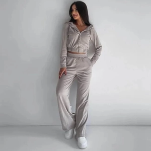 Dettaglio della tuta in velluto grigio chiaro con felpa con cappuccio e pantaloni larghi