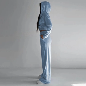 Dettaglio di tuta in velluto azzurro con felpa corta con cappuccio e pantaloni larghi