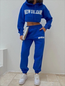 Detail eines königsblauen Fleece-Trainingsanzugs mit weißem New Orleans Aufdruck am Crop Top