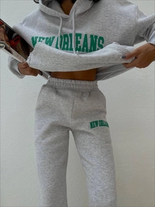 Detail eines Fleece-Trainingsanzugs mit New Orleans-Aufdruck auf grauem Hoodie und Hose