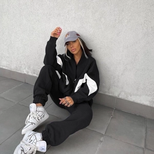 Dettaglio del set sportivo nero con maniche a contrasto bianco e giacca con zip alta