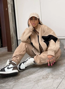 Dettaglio della tuta in pile beige con patchwork di stelle e collo con zip sul modello