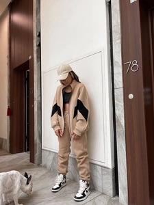 Dettaglio della tuta sportiva color kaki con inserto a contrasto nero e pantaloni jogger