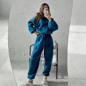Detailed view of dark blue tracksuit featuring cargo pockets and ribbed cuffs