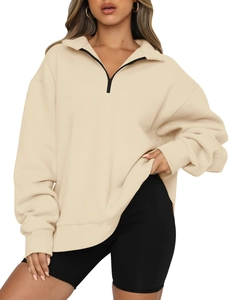 Detail view of cream half-zip oversized sweatshirt with contrast black zipper and soft fabric