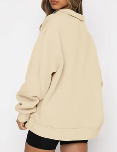 Rear view of an oversized beige hoodie featuring dropped shoulders and ribbed cuffs