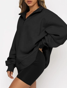 Side view of black oversized half-zip sweatshirt with dropped shoulders and relaxed fit