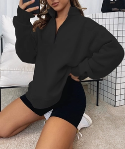 Detail of a black half-zip oversized sweatshirt with drop shoulder and metal zipper