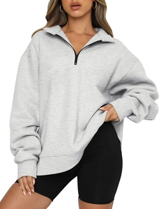 Detail of light gray oversized sweatshirt with half-zip collar and ribbed cuffs