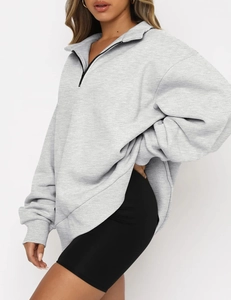 Close-up of gray oversized sweatshirt featuring half-zip collar and soft marl texture