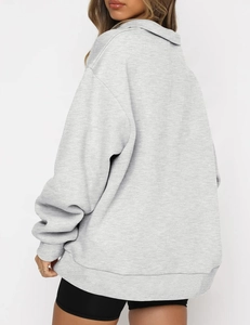 Detail of light grey oversized hoodie showing drop shoulder and knitted texture