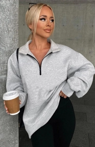 Detail of grey quarter-zip sweatshirt showing heavy knit fabric texture and drop shoulder