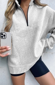 Detail of grey half-zip sweatshirt with stand collar and dropped shoulder fit on model