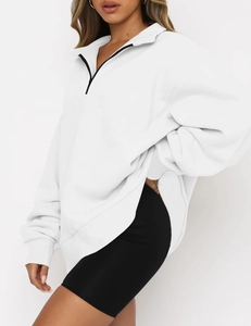 Close-up of white quarter-zip long sleeve sweatshirt with contrast black zipper detail
