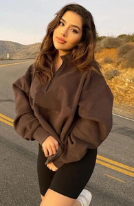 Outdoor view of dark brown half-zip sweatshirt with drop shoulders and relaxed fit