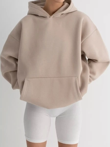 Detail of beige oversized hoodie featuring dropped shoulders and a large kangaroo pocket